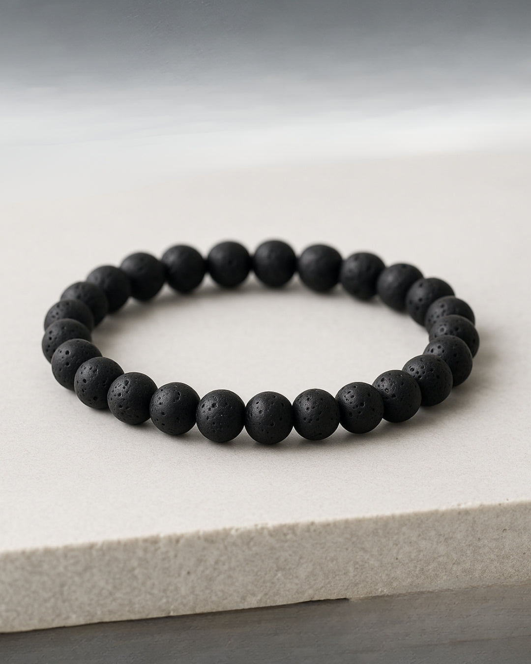 Black beaded bracelet on a light gray surface
