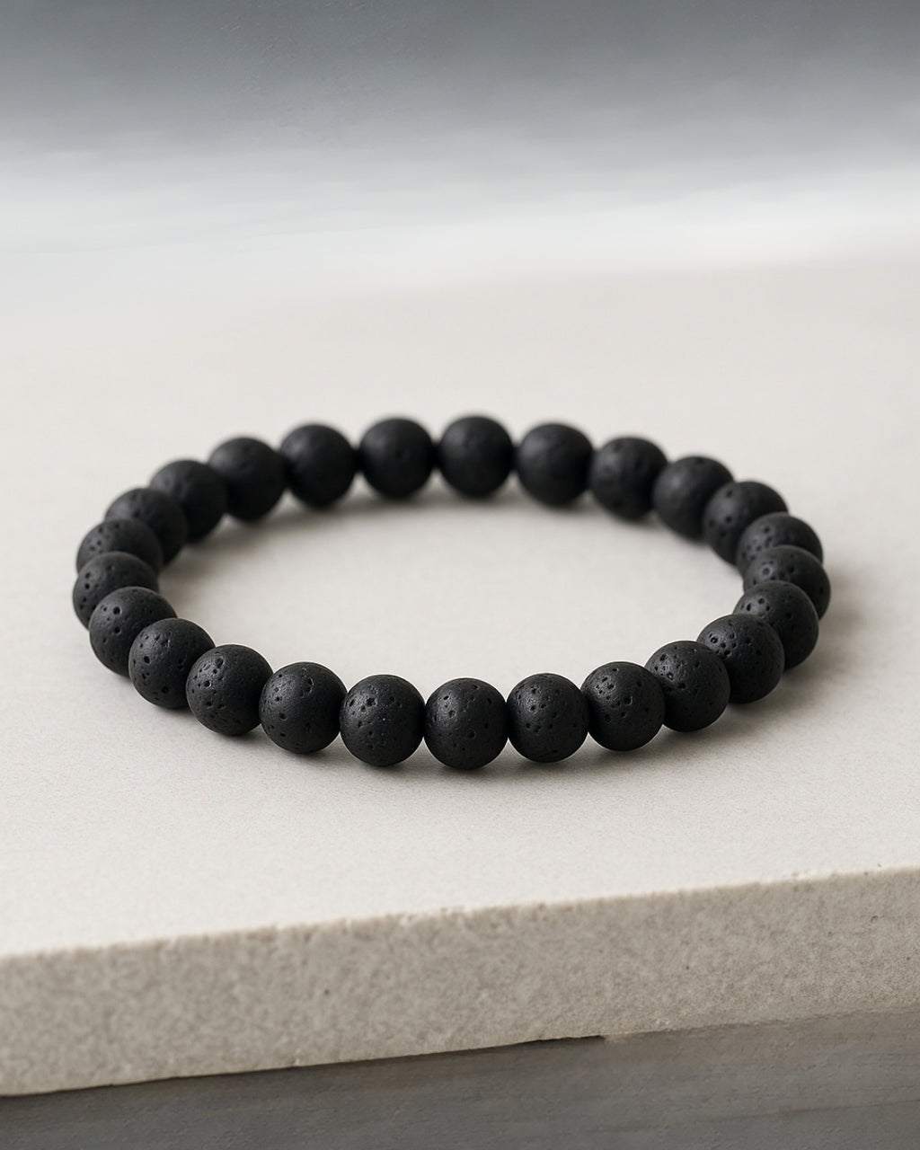 Black beaded bracelet on a light gray surface